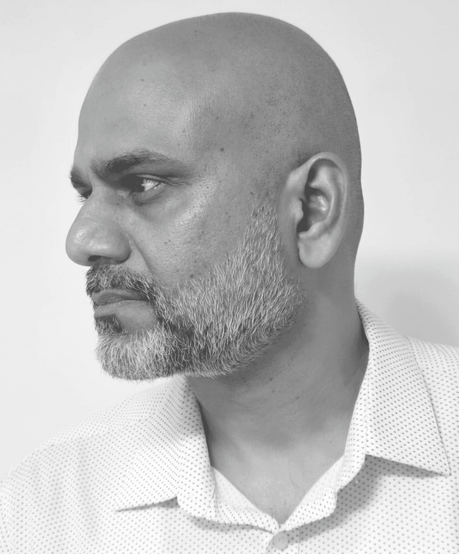 Black and white portrait of author Yashasvi Prasad looking thoughtfully with an open book when staying stop making sense